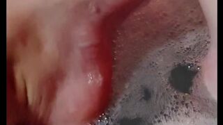 Hot blonde massaging her wet soapy feet in the bath